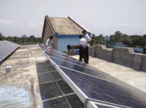 School students and staffs clean solar rooftop panels at the Akshaynagar Jnanadamoyee Vidyaniketan school in Kakdwip